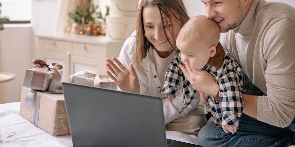 A heartfelt scene of a mother and child looking at a video call on a laptop, with the father's face visible on the screen, capturing the emotional connection despite the physical distance and the implications for child support.